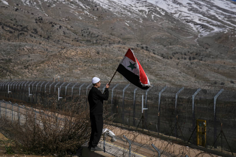 Молодой человек с сирийским флагом на линии контроля на Голанских высотах