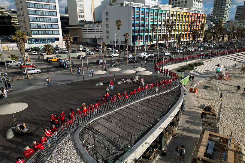 Жительницы Тель-Авива, одетые в красное, выстроились в живую цепь в рамках демонстрации против судебной реформы в Международный женский день