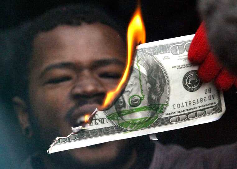 В огне горит, в воде тонет&lt;br>
Портленд, США. Протестующий сжигает стодолларовую купюру возле офиса Банка Америки, 2011 год