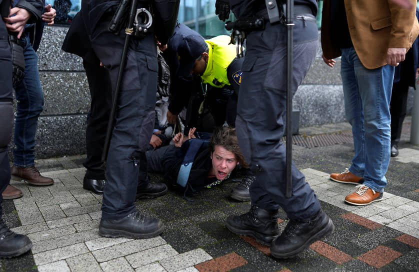 Амстердам, Нидерланды. Полицейские задерживают демонстранта перед прибытием президента Франции Эмманюэля Макрона и короля Нидерландов Виллема-Александра