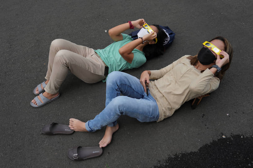 Гибридное затмение является редким феноменом и происходит несколько раз в столетие&lt;br>
На фото: жители Джакарты в Индонезии наблюдают за солнечным затмением в защитных очках