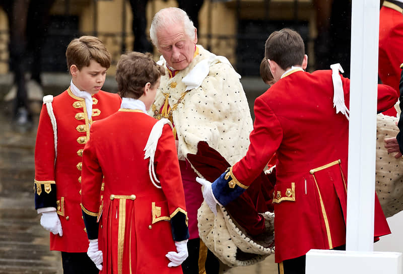 Британский принц Джордж (слева) наблюдает, как король Карл III прибывает на свою коронацию