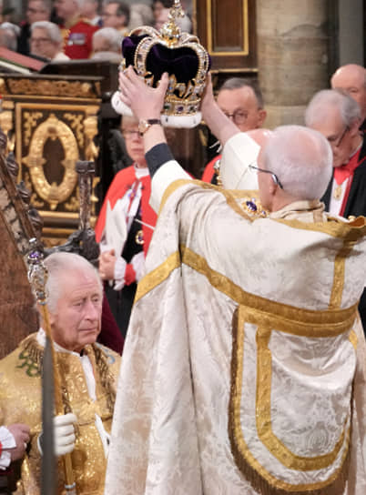 Архиепископ Кентерберийский Джастин Уэлби надевает корону на голову короля Карла III
