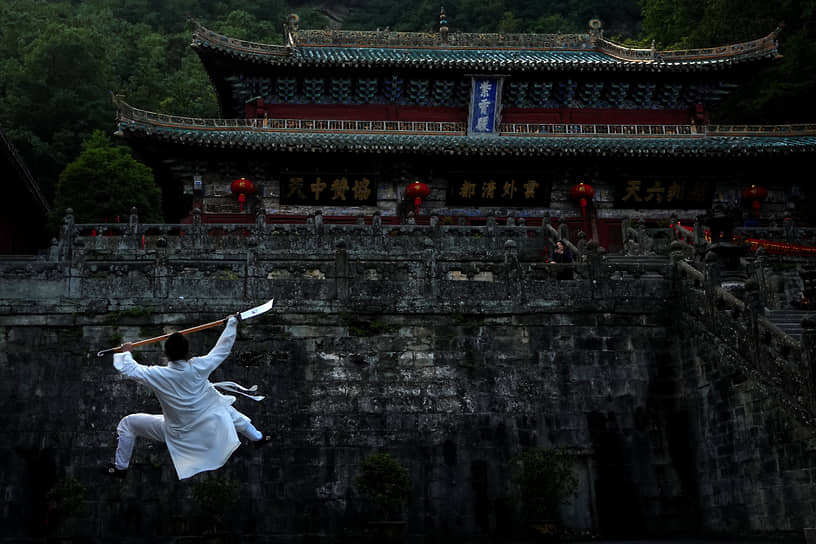 Хубэй, Китай. Даос практикует тай-чи во дворце Цзысяо на горе Уданшань 