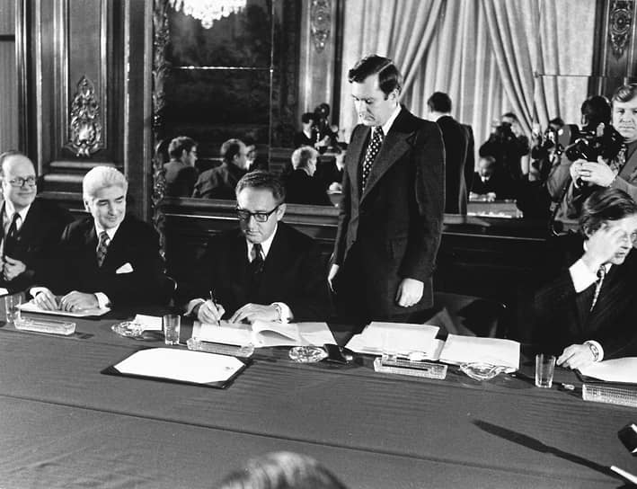 Генри Киссинджер (в центре) подписывает Парижское мирное соглашение. 23 января 1973 года