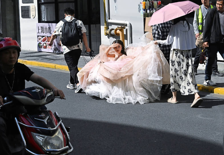 Шанхай. Девушка в свадебном платье едет на фотосессию на повозке