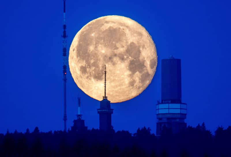 Германия. Луна садится за здания на вершине горы Фельдберг