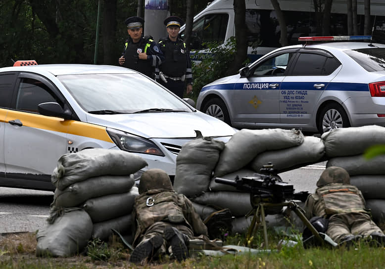 Военнослужащие с гранатометом АГС-30 на стрелковой позиции из мешков с песком на съезде с МКАД в Ясенево