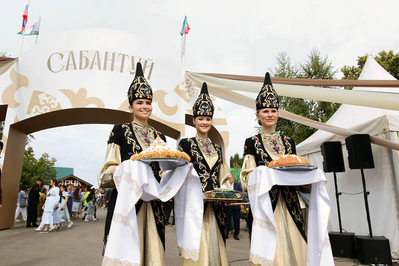 Девушки в национальных костюмах с угощением 