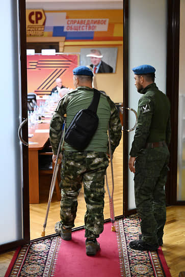 Ветеран специальной военной операции Алексей Сыромятников (слева, спиной) перед началом заседания