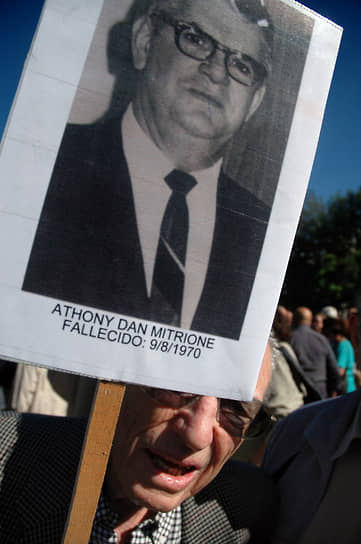 Отставной уругвайский военный держит транспарант с портретом жертвы террора, американского специалиста по пыткам Дэна Митрионе, на демонстрации в Монтевидео. 2007 год
