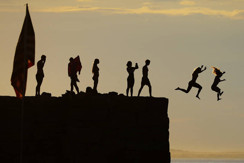 Глостер, США. Дети прыгают в океан с волнолома