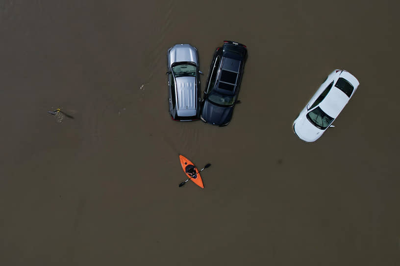 Монпелье, США. Каноэ проплывает мимо затопленных ливнями автомобилей 
