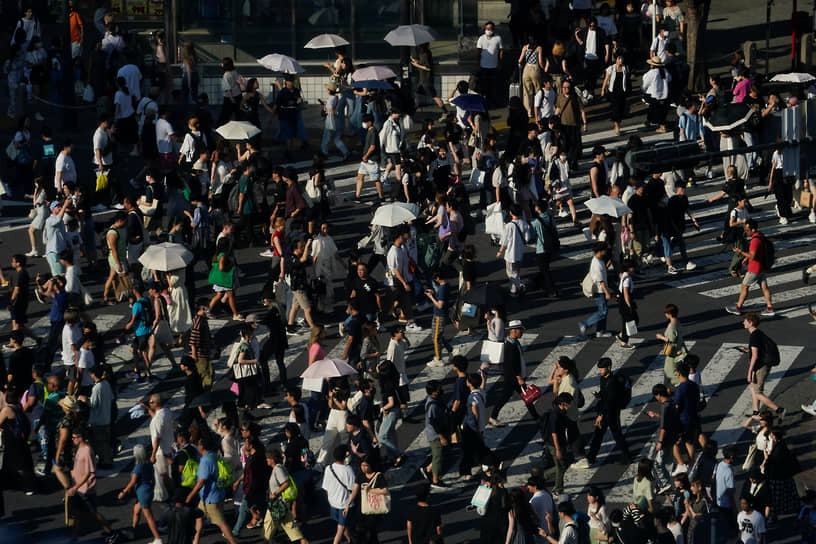 Токио, Япония. Местные жители и туристы спасаются от жары с помощью зонтиков