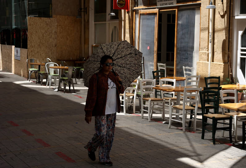 Никосия, Кипр. Девушка скрывается от солнца под зонтиком