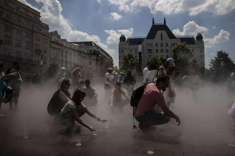 Будапешт, Венгрия. Туристы охлаждаются с помощью городской системы туманообразования