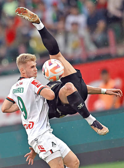 Москва. Футболист «Урала» (справа) пытается нанести удар в прыжке