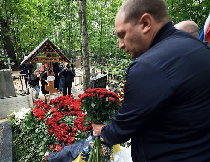 Люди возлагают цветы к могиле Евгения Пригожина