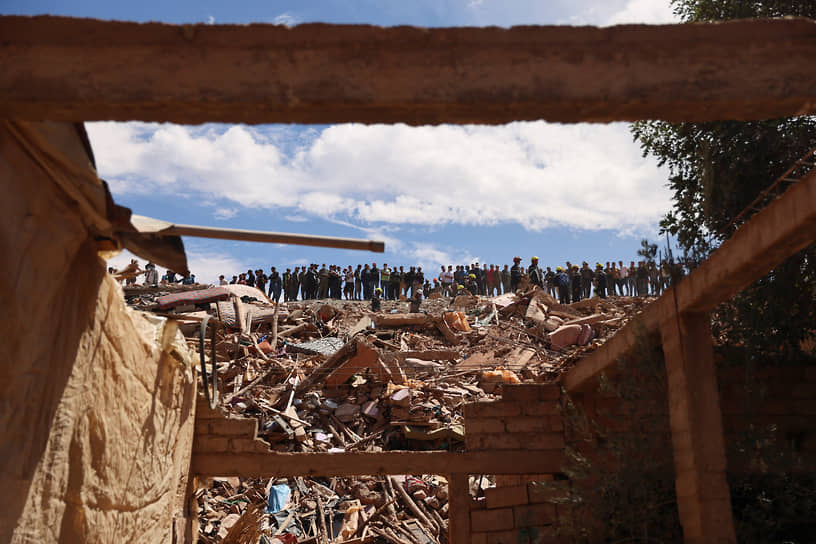 Талат-Ньякуб, Марокко. Люди наблюдают, как спасатели разбирают завалы после землетрясения, унесшего жизни более 2,5 тыс. человек