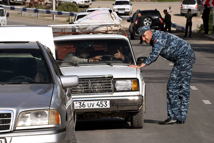 Сотрудник полиции и беженцы из Нагорного Карабаха на приграничном блок-посту в Корнидзоре