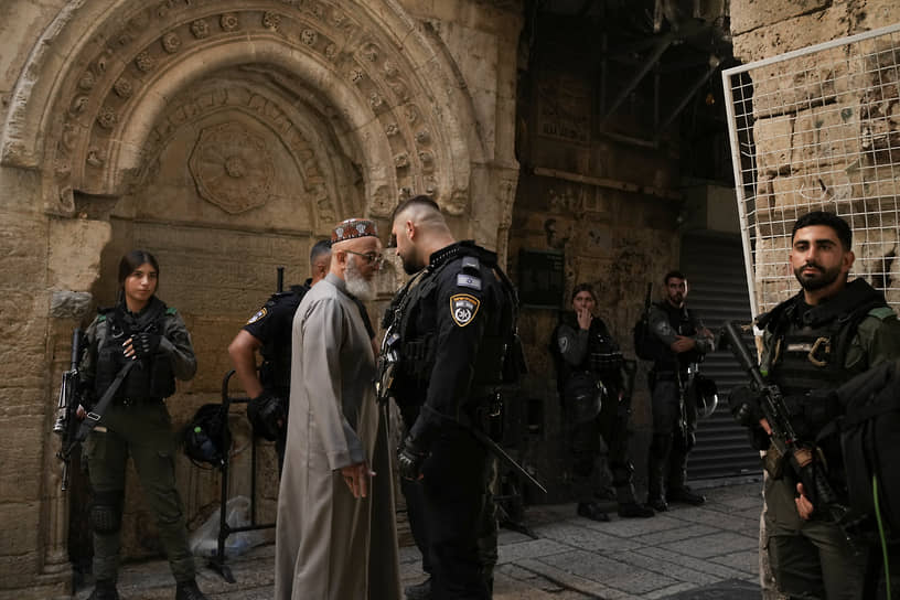 Израильский полицейский разговаривает с верующим, направляющимся на молитву в мечеть Аль-Акса в Иерусалиме