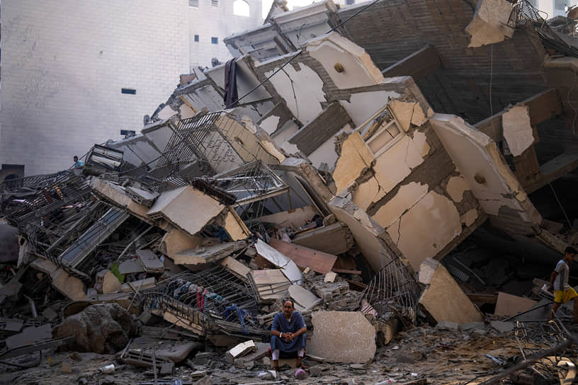 Палестинец среди обломков здания после израильского авиаудара в секторе Газа