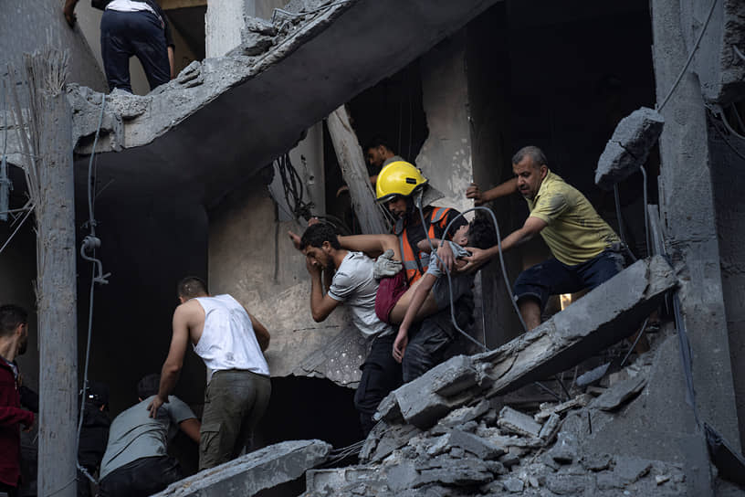 Эвакуация пострадавших из здания, разрушенного в результате израильского удара по Хан-Юнису 