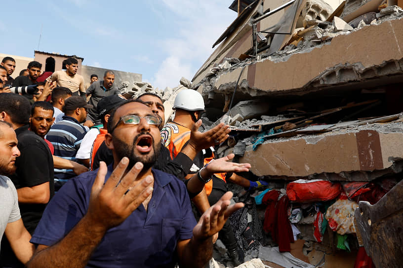 Палестинцы обыскивают обломки дома, разрушенного в результате израильских ударов в Хан-Юнисе 