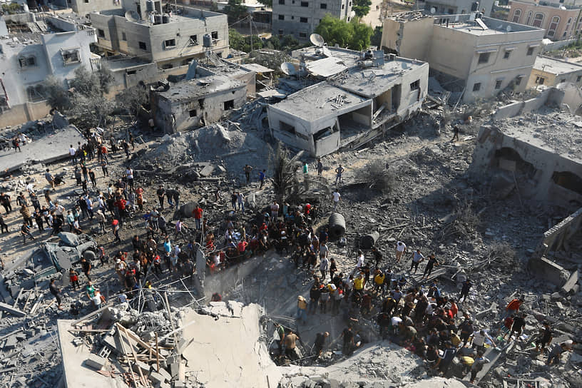 Местные жители ищут пострадавших под завалами после израильских обстрелов в Хан-Юнисе (сектора Газа)