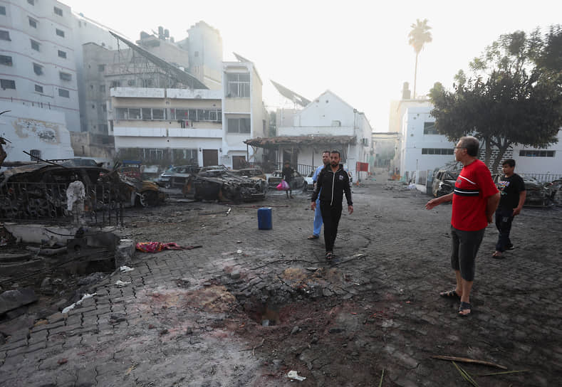 Местные жители на территории больницы Аль-Ахли в Газе после ракетного удара