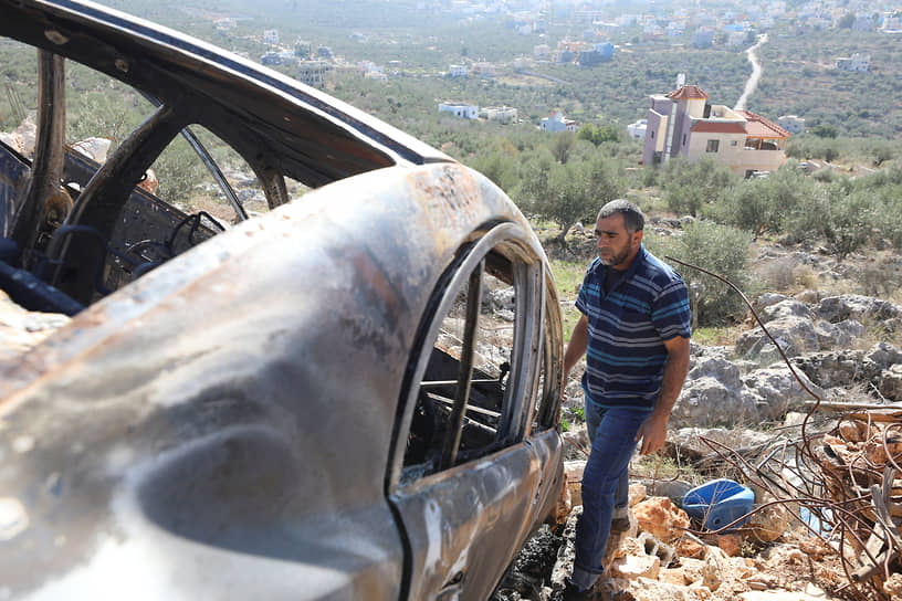 Палестинец у сгоревшего автомобиля