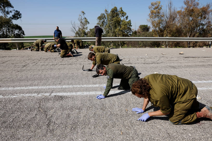 Израильские военные недалеко от границы с сектором Газа осматривают дорогу в поисках останков и улик, связанных с нападением «Хамаса»