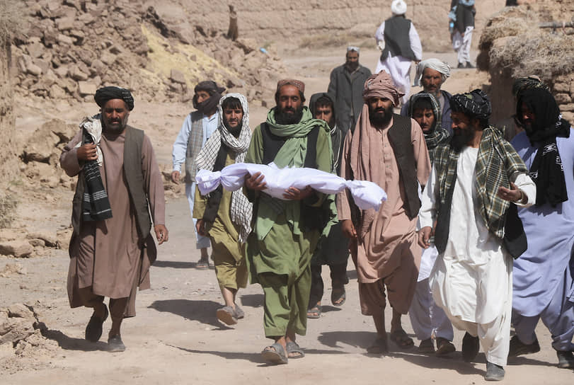 Герат, Афганистан. Мужчина несет тело ребенка, погибшего 
в результате землетрясения 
