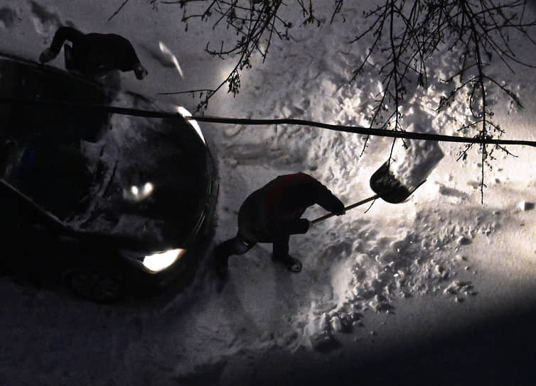 Москва. Автомобилист чистит дорогу от снега