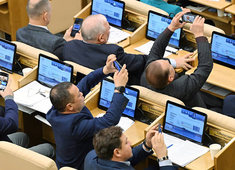 Москва. Депутаты Госдумы снимают на мобильные телефоны результаты голосования на электронном табло в зале заседаний