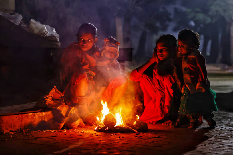 Дакка, Бангладеш. Бездомные разжигают костер, чтобы согреться 