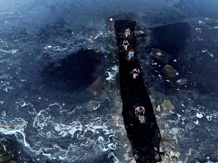 Нортумберленд, Великобритания. Люди выходят из воды после занятий по плаванию в озере Суитхоп 