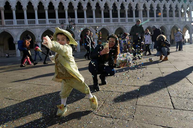 Ребенок бросает конфетти на площади Сан-Марко
