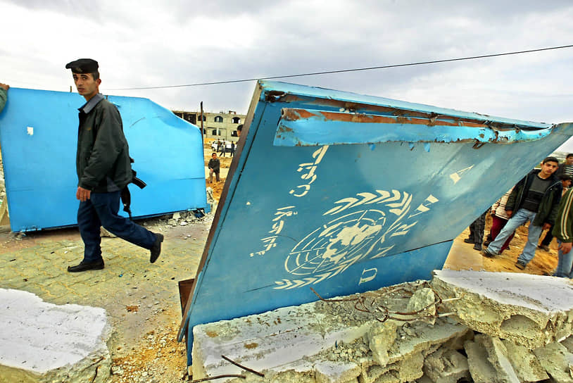 Палестинский полицейский у входа в разрушенную израильтянами школу в Бейт-Лахия, содержавшуюся на средства БАПОР