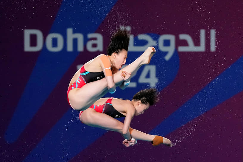 Китаянки Чэнь Юйси и Куан Хонгчан выступают в финальных соревнованиях по синхронным прыжкам в воду с 10-метровой вышки
