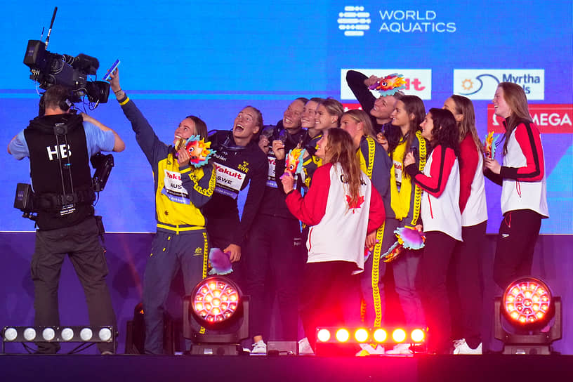 Серебряные призеры из сборной Швеции, золотые призеры из команды Австралии и бронзовые призеры из Канады позируют с медалями после финала женской эстафеты 4х100 м 