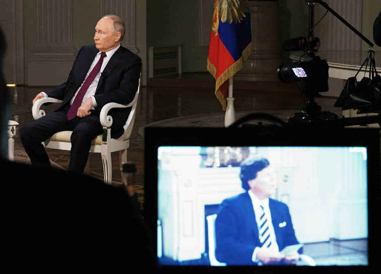 Президент России Владимир Путин и американский журналист Такер Карлсон (на экране)