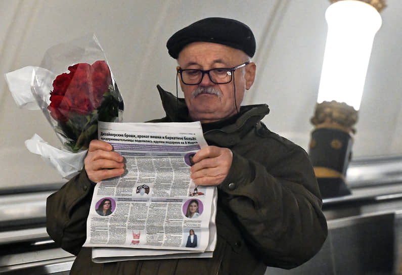 Мужчина с букетом роз на эскалаторе в метро 