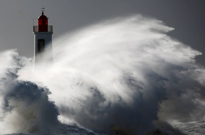 Ле-Сабль-д&#39;Олон, Франция. Маяк накрывают волны в разгар шторма Нельсон 