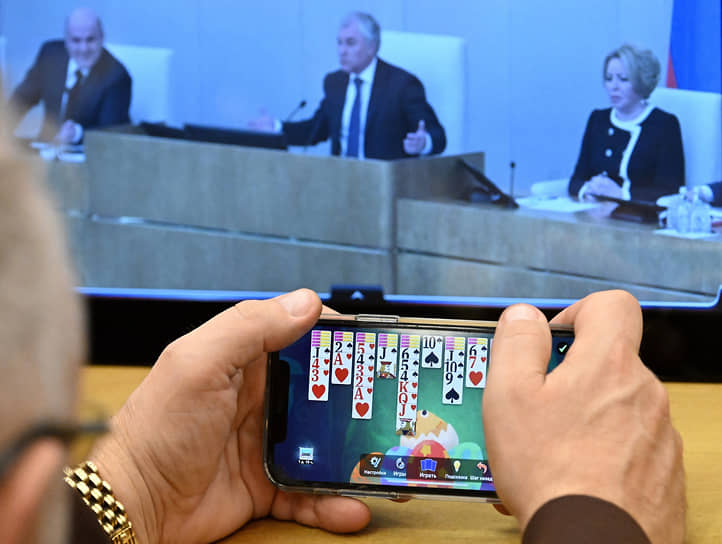 Москва. Депутат играет в пасьянс на мобильном телефоне во время пленарного заседания 