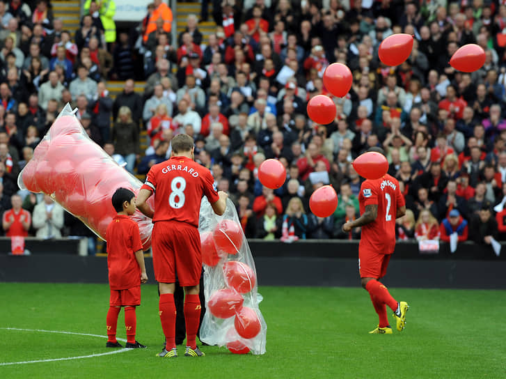 Капитан «Ливерпуля» Стивен Джеррард (в центре) отпускает в воздух 96 шаров в память о болельщиках, погибших в давке на стадионе «Хиллсборо» перед матчем против «Манчестер Юнайтед», 2012 год