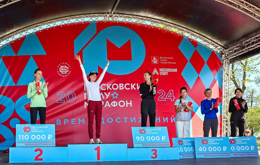 Победители забега среди женщин Анна Викулова (вторая слева), Елена Седова (слева) и Ольга Немогай (третья слева) на церемонии награждение
