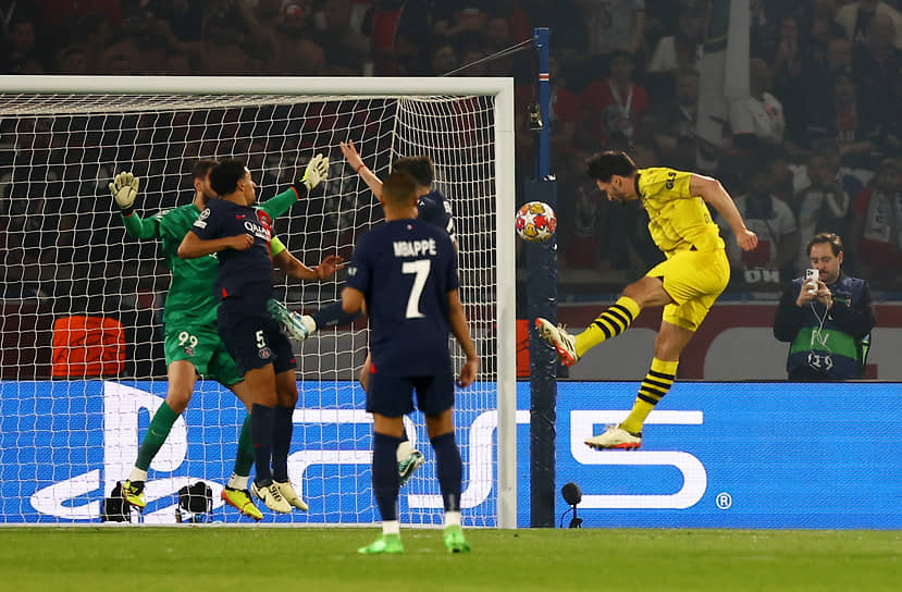 Защитник дортмундской «Боруссии» Матс Хуммельс (в желтой форме) забивает победный гол в ворота ПСЖ