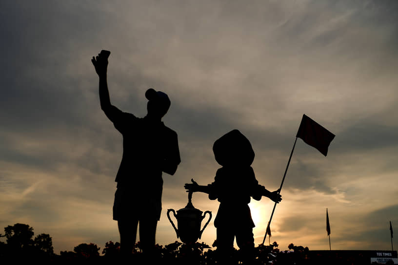 Паинхерст, США. Болельщик фотографируется у статуи «Мальчик с клюшкой» на Открытом чемпионате США по гольфу