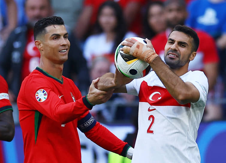 Португалец Криштиану Роналду (слева) и турок Зеки Челик в борьбе за мяч